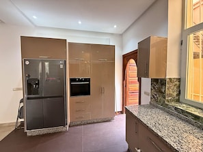 Eine Küche mit Einbaukühlschrank, Backofen und Doppeltüren.
