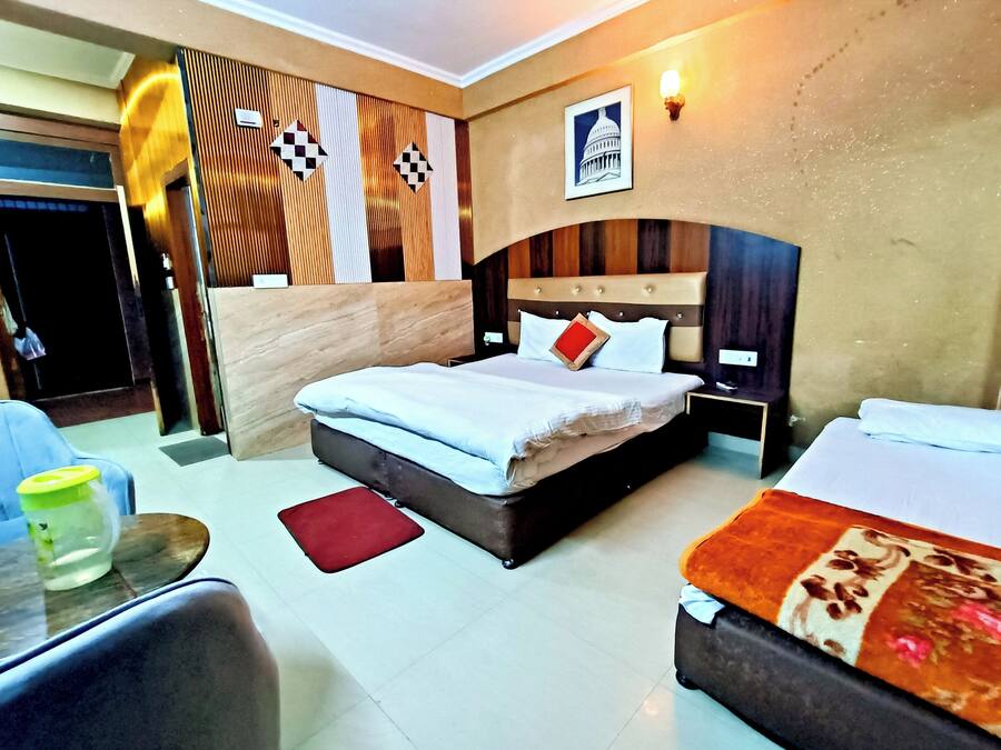 A hotel room with a large bed, a smaller bed, a desk, and a chair.