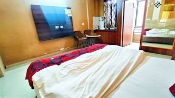 A hotel room with a bed, a desk, and a chair.
