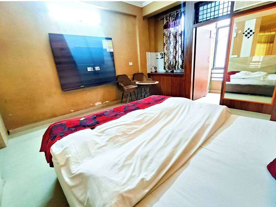 A hotel room with a bed, a desk, and a chair.