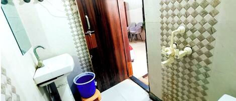 Un baño con lavamanos, inodoro y zona de ducha.