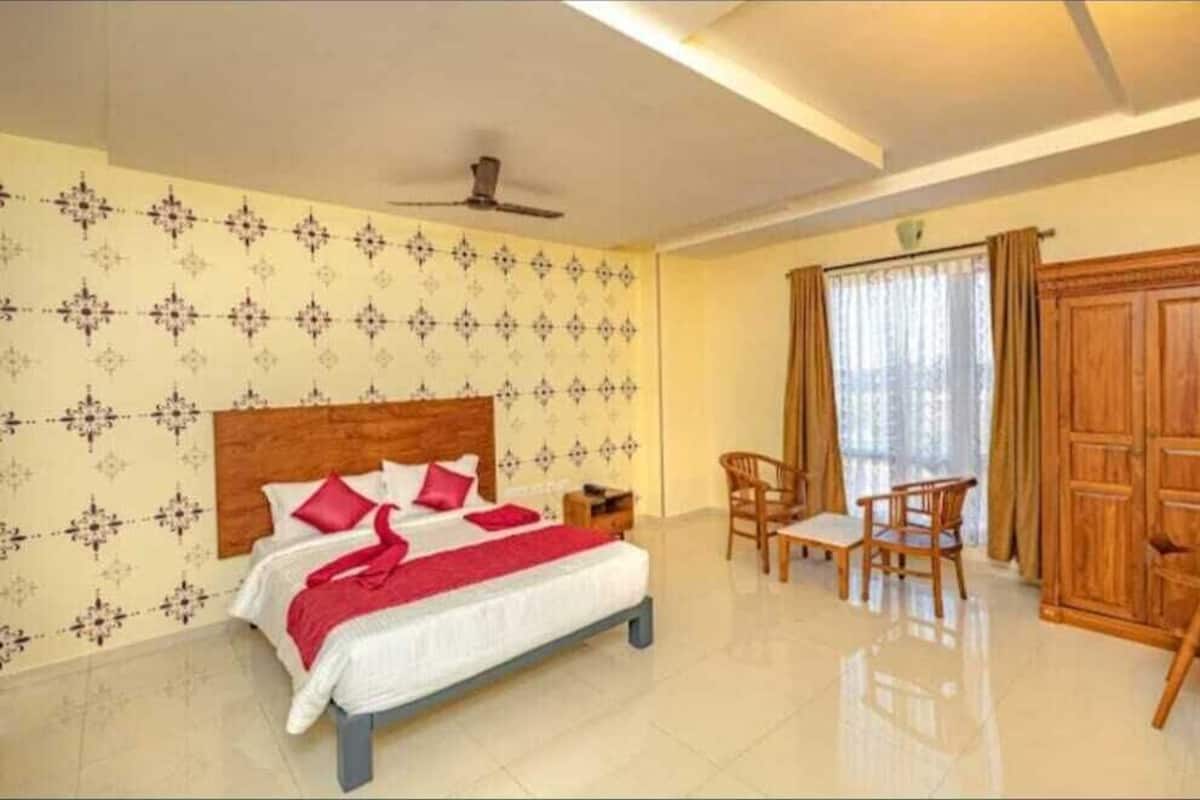 Una habitación de hotel con cama, escritorio y armario.