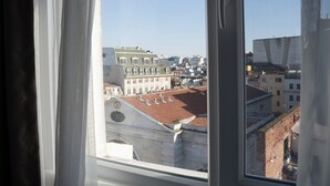 Vista desde una ventana mostrando un paisaje urbano con edificios y cielo despejado.