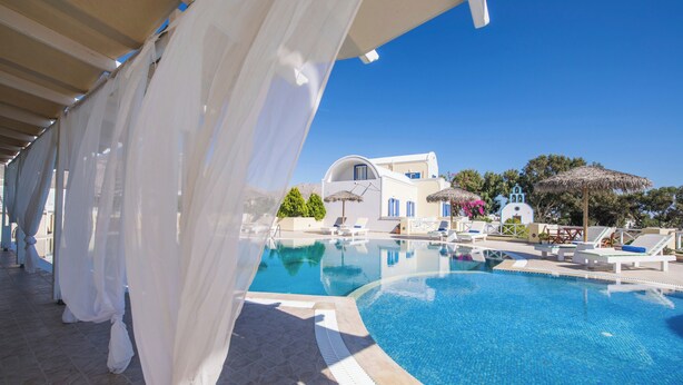 A clear blue pool with white curtains and a white building in the background. - 1-bed Apt at Bella Santorini, Near Perivolos Beach (Santorini)