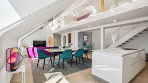 Un interior moderno con comedor, cocina y escalera.