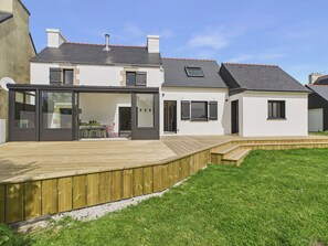 A modern house with a deck, a covered patio, and a well-maintained lawn. - Beach 300m away, house for 7, garden and veranda (Plouguerneau)