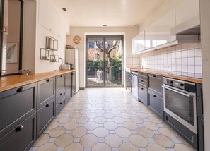 Een koelkast, een oven, een broodrooster, kookgerei, borden en bestek