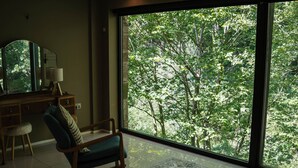 A room with a large window, a rocking chair, a desk with a lamp, and a mirror. - The Heronry (Carlisle)