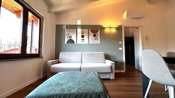Une pièce comprenant un canapé, une petite table, une chaise et des œuvres d’art accrochées au mur.