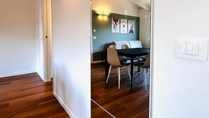 A hallway with wooden flooring, a dining area with a table and chairs, and a ceiling with exposed beams. - Casa Paolina Apartment - Lomazzo (Lomazzo)