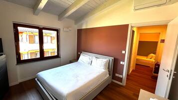 Une chambre à coucher avec un lit, une fenêtre, une porte et une petite table de chevet.