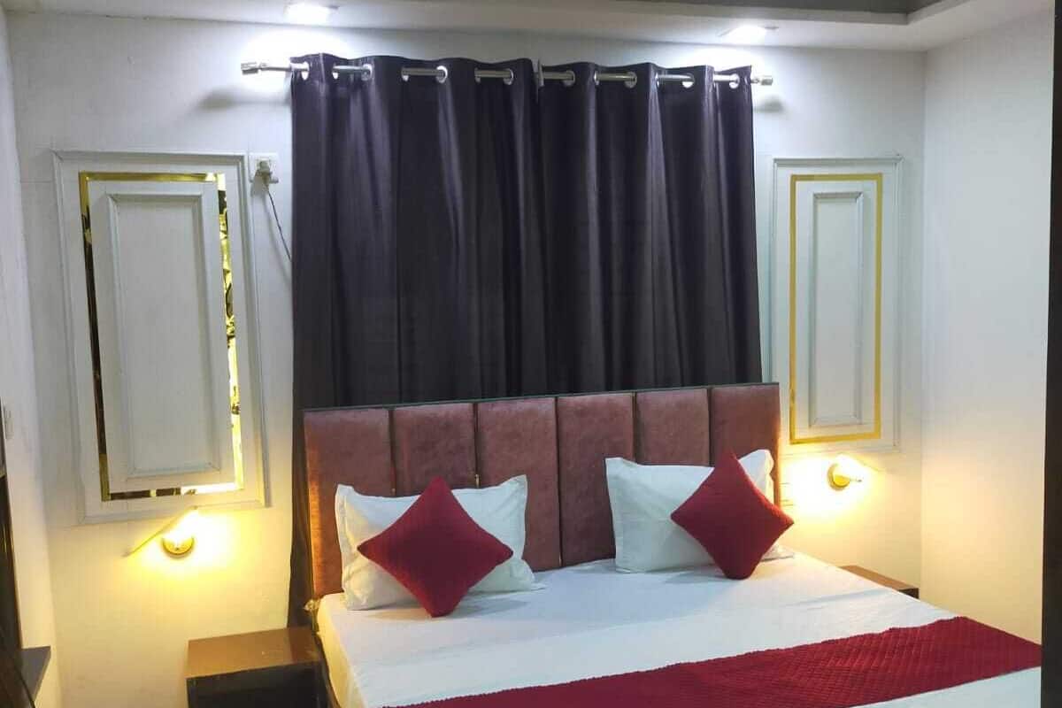 A hotel room with a bed, a ceiling fan, and a nightstand.