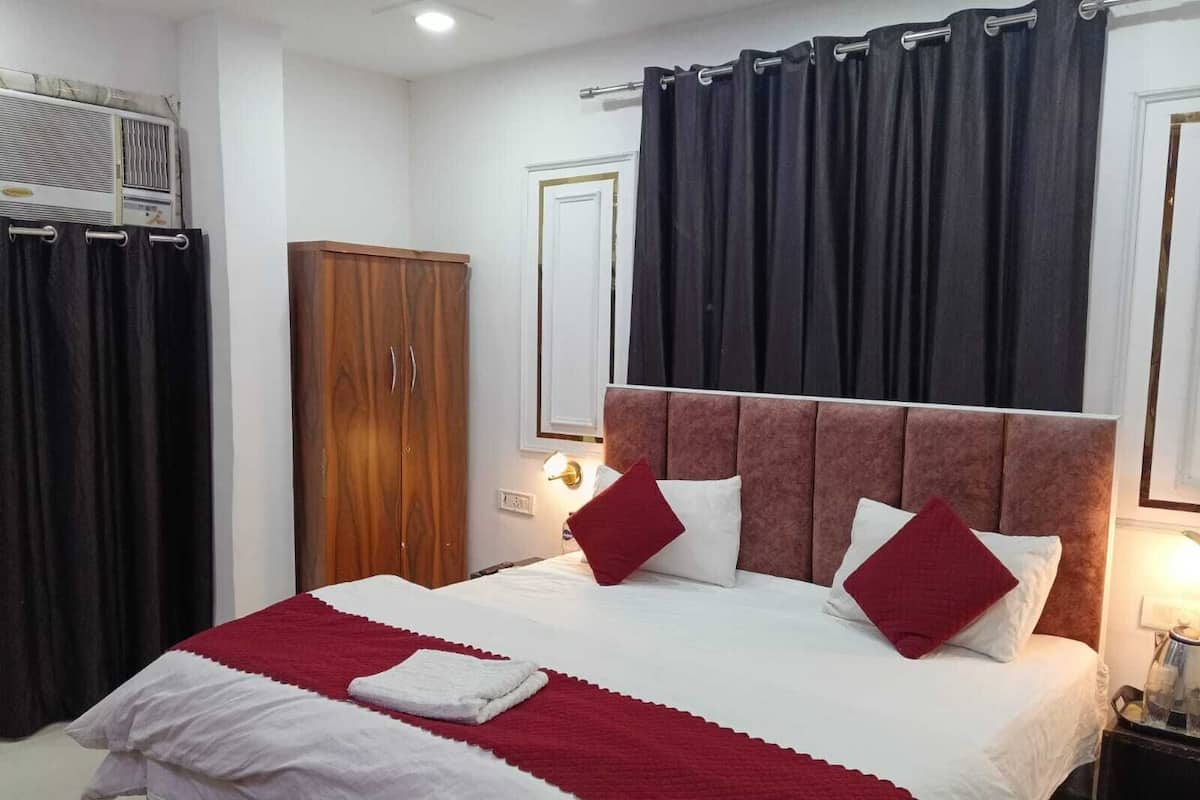 A bedroom with a bed, a wardrobe, and a nightstand.