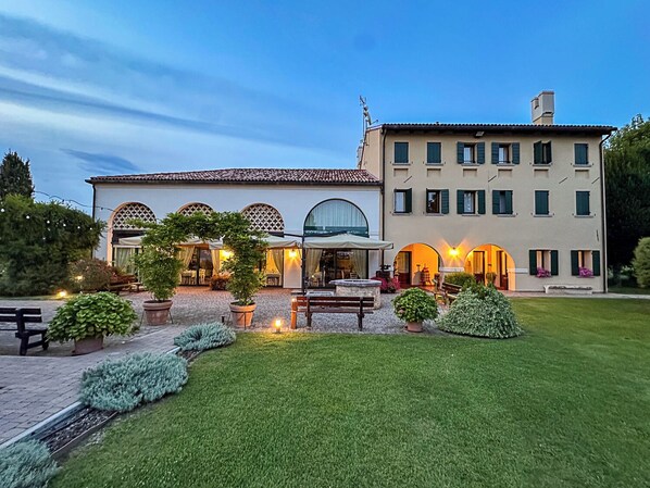 A hotel with a courtyard, outdoor seating, and a well-maintained garden.