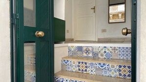 Una escalera con baldosas decoradas y una puerta verde.