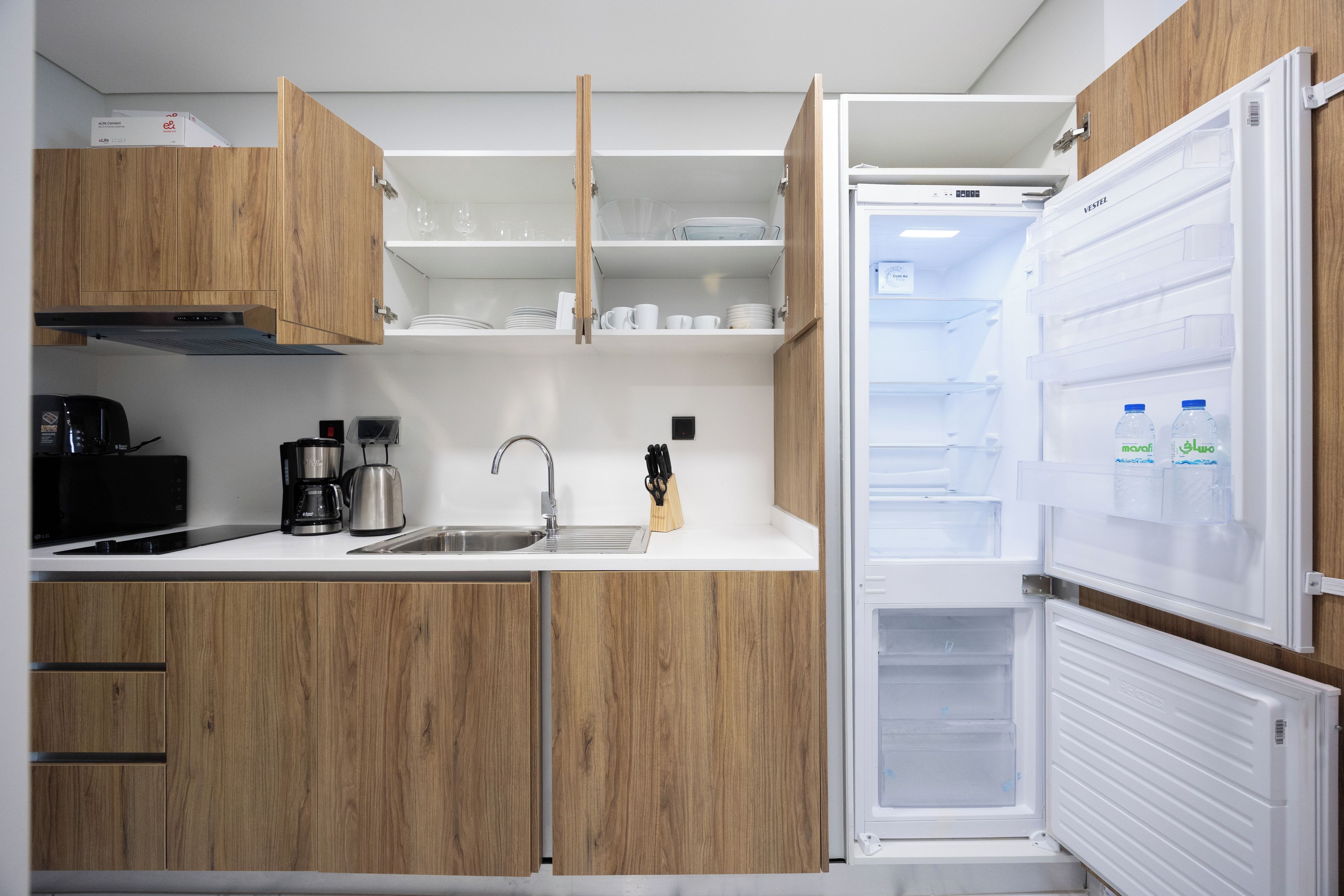 Eine moderne Küche mit Holzausstattung, Spüle und Kühlschrank mit Wasserspender.