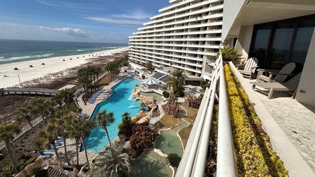 Ein Hotel mit Pool, Meerblick und mehreren Balkonen.