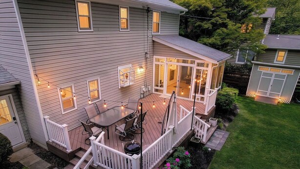 A two-story house with a deck, a patio with a table and chairs, and a small garden area. - 4BR Family Retreat Near Annapolis w/ Large Yard (Annapolis)