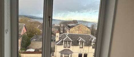 A room with a large window overlooking a residential area.
