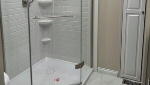 A glass-enclosed shower with white tiled walls and a white door. - 4-bedroom houseboat in historic Old Kuttawa, KY (Kuttawa)