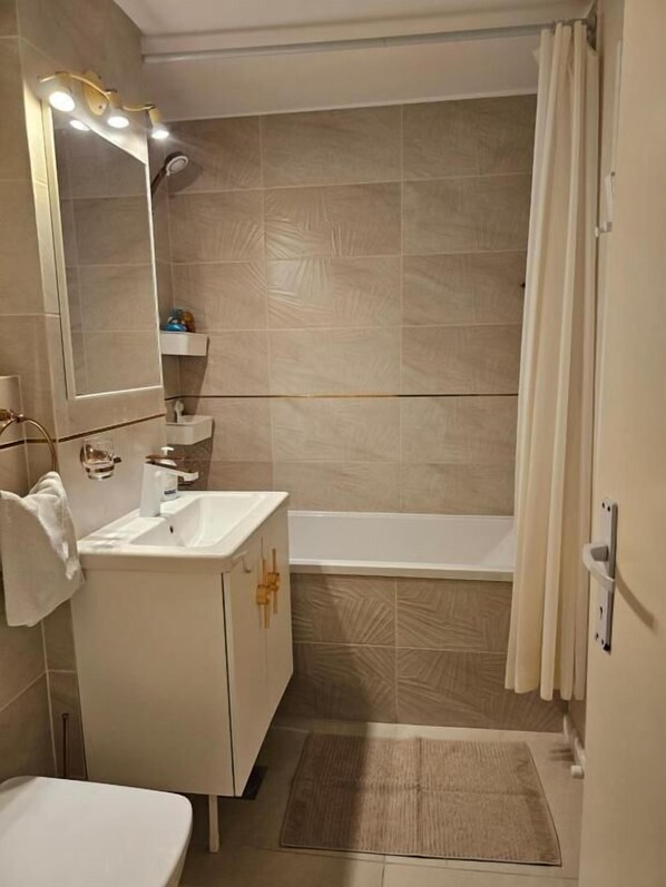 A bathroom with a sink, mirror, and bathtub. - Apartament David cu 2 dormitoare (Deva)
