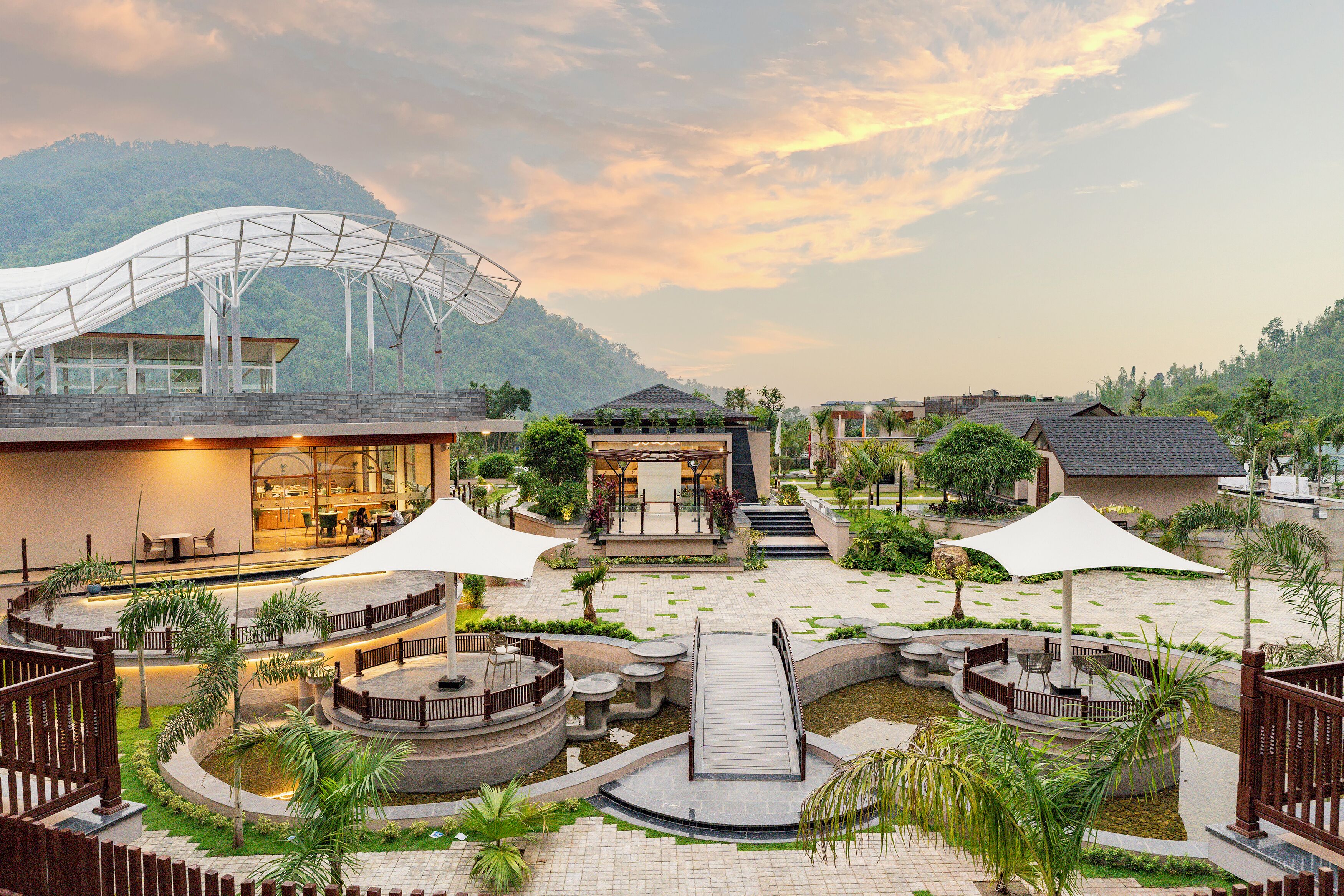 A resort with a central courtyard, outdoor seating, and a covered area.