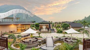 A resort with a central courtyard, outdoor seating, and a covered area.