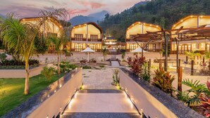 A resort with multiple connected buildings, a central courtyard, and surrounding greenery. - Latauli Sanctuary (Kalika)