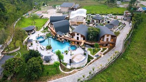 A resort with a swimming pool, multiple buildings, and a surrounding landscape. - Latauli Sanctuary (Kalika)