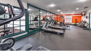 Ein Fitnessstudio mit Laufbändern, Ergometer und einer Spiegelwand.