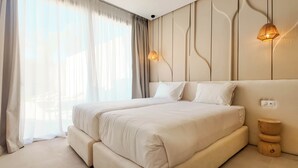 A modern bedroom with a large bed, a bedside table, and a wall-mounted light fixture. - Bungalow Palmeraie-Heated swimming pool not overlooked (Marrakech)