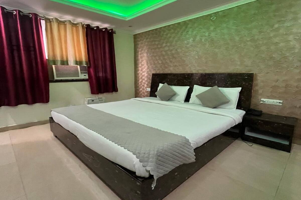 Un dormitorio con una cama grande, ventilador de techo y ventana con cortinas.