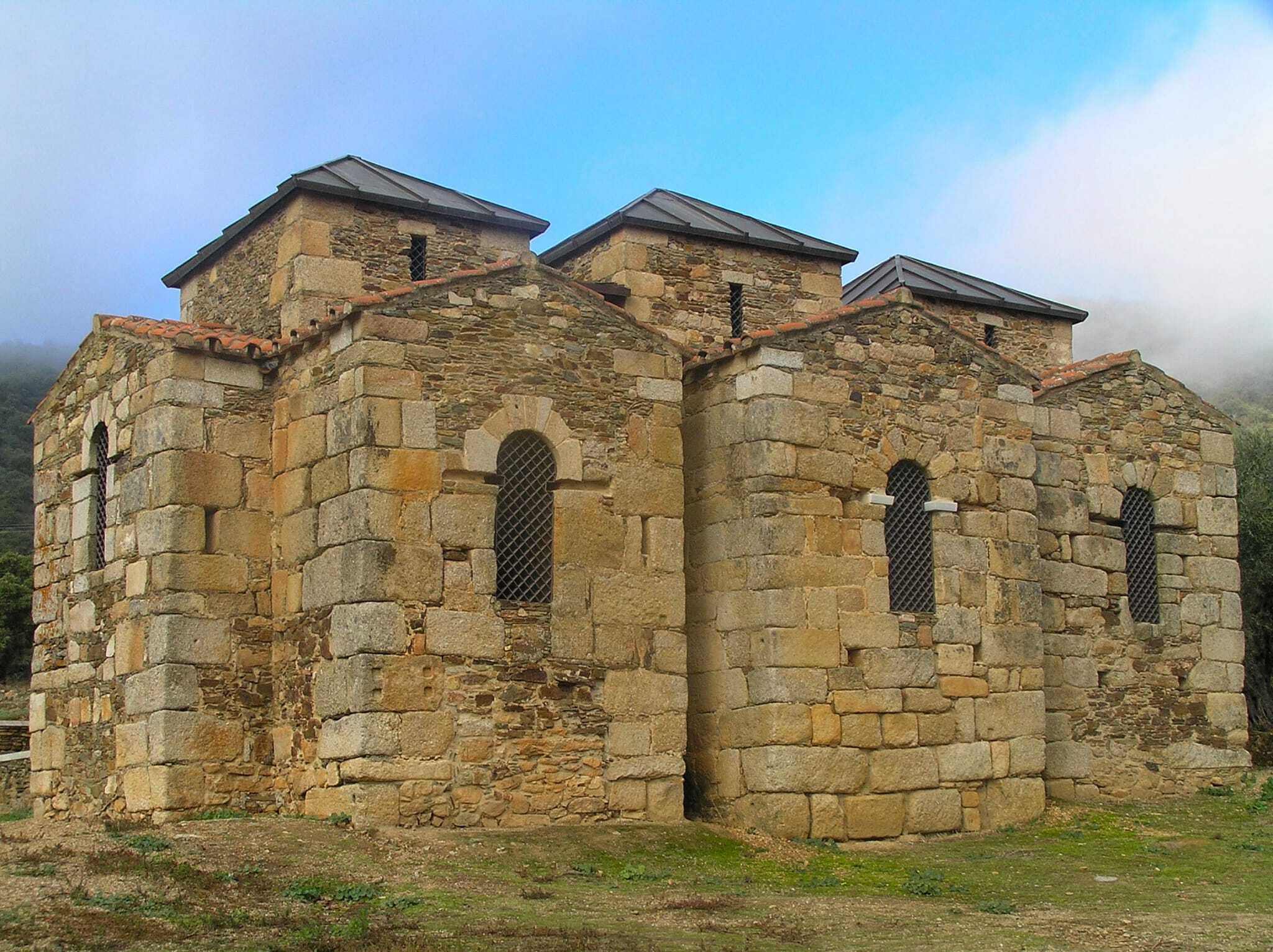 Un edificio de piedra con ventanas de arco y tejado de tejas.