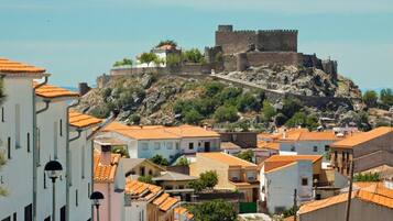 A historic fort on a hill overlooking a town with traditional buildings.