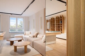 A modern living room with a sofa, two round tables, a window with blinds, and a wooden shelving unit. - HoliApart Trimare Billard &Seasonal Pool (Sztutowo)