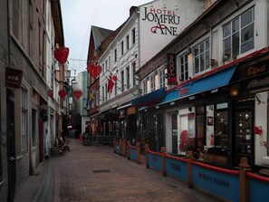Een smalle straat met gebouwen, waaronder Hotel Jomfru Ane.