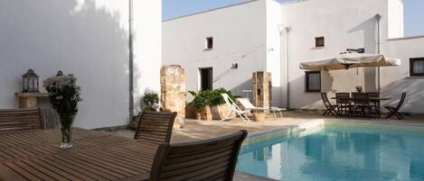 Piscine extérieure en saison, parasols, chaises longues