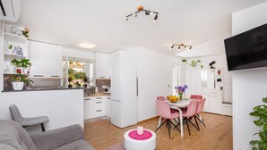 Un appartamento moderno con cucina, zona pranzo e soggiorno.