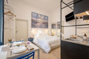 Ein Hotelzimmer mit einem Bett, einem Nachttisch und einem an der Wand befestigten Fernseher.