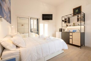 A modern hotel room with a bed, a desk, a mirror, and a framed sign on the wall. - A cozy apartment with a true maritime soul (Bari)