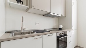 A modern kitchen with a stainless steel sink, a coffee maker, and a built-in oven. - GuestHost - Comfortable and cozy 35 square meters studio apartment, perfect for two people, located on the ground floor of a building.The property is located near the Gambara M1 metro station (5 minutes' walk), offering quick access to Milan's most centr (Milan)