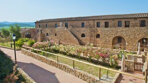Un edificio de piedra con ventanas de arco y un sendero adoquinado.