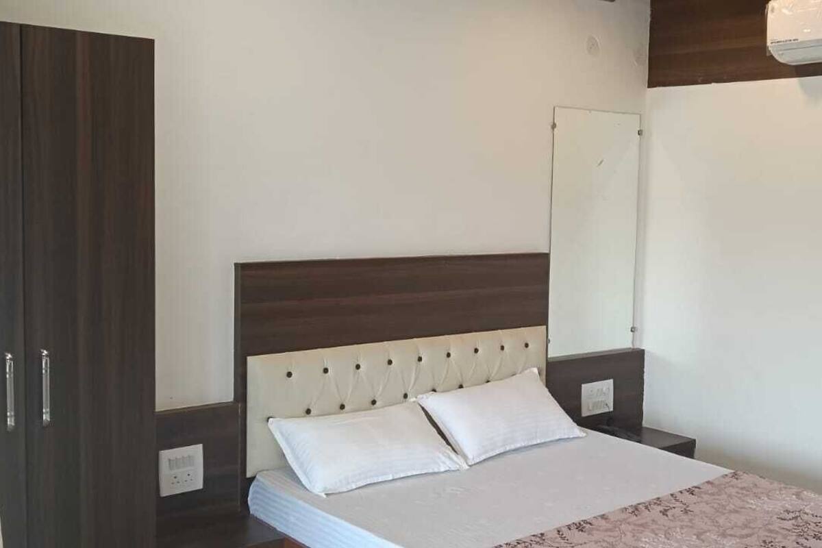 A bedroom with a bed, a wardrobe, and a mirror.
