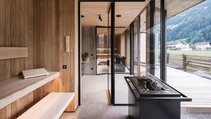 A modern interior with wooden paneling, a bench, a display case, and a view of the outdoors.