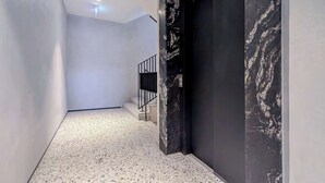 Ein Korridor mit einer Marmorwand und einer Tür.