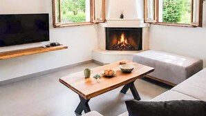 En moderne stue med pejs, et fladskærms-tv og en sofa.
