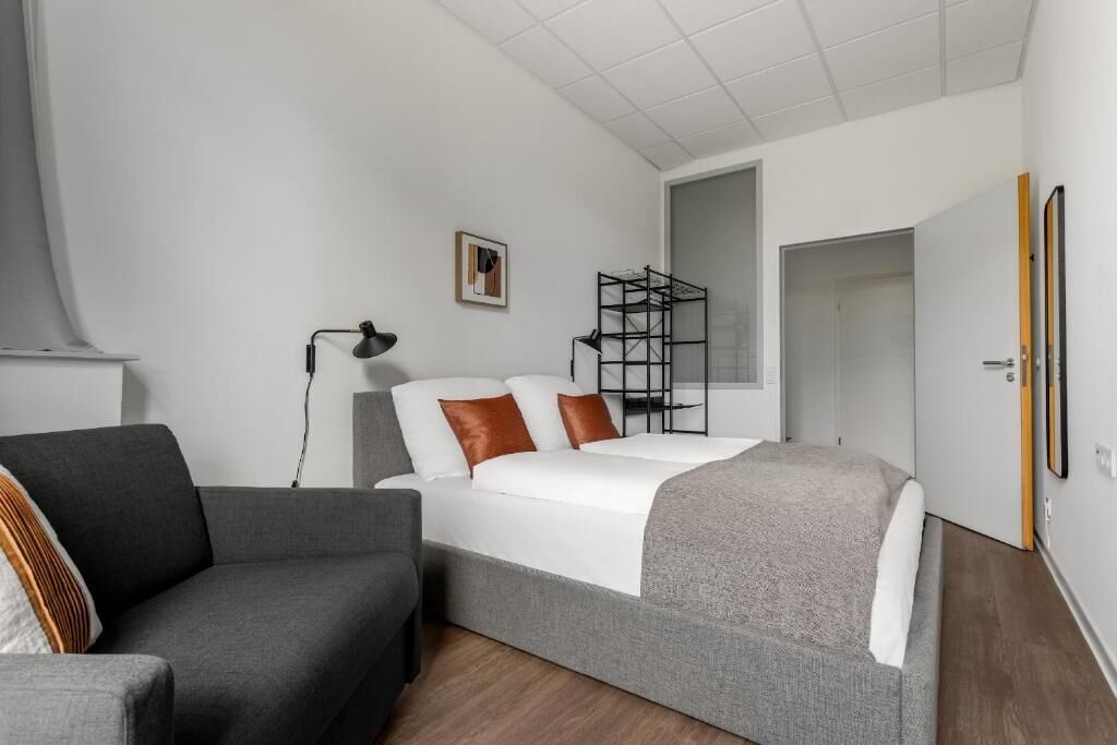 Una camera da letto moderna con un letto, una scrivania e una sedia.