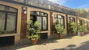 A building with a brick facade, large windows, and potted plants. - ACasaDiImma Vicino Metro Wi-Fi Luminoso (Milan)