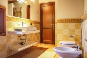 A bathroom with a sink, mirror, toilet, and shower area. - Villa Erika SicilyMyHome (Ispica)