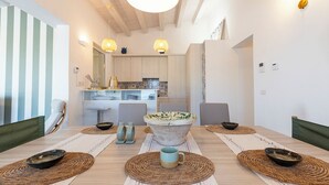 A dining area with a large table, woven placemats, and a central decorative bowl. - Villa Elysian con Piscina Privata (Pachino)